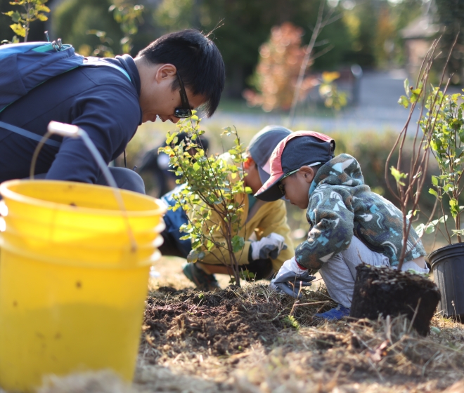 Adult and children planting trees